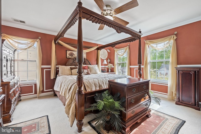 bedroom featuring wainscoting, light colored carpet, ornamental molding, and visible vents