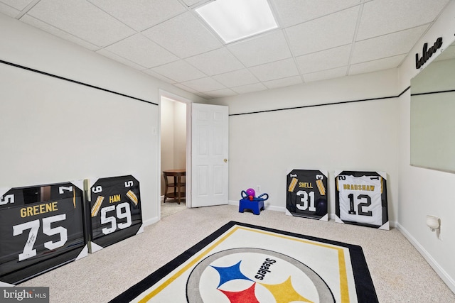playroom featuring a paneled ceiling, carpet flooring, and baseboards