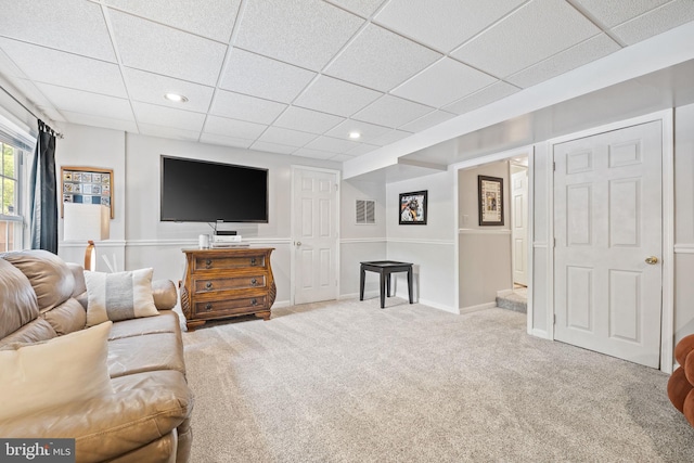 carpeted living area with baseboards, a drop ceiling, and recessed lighting