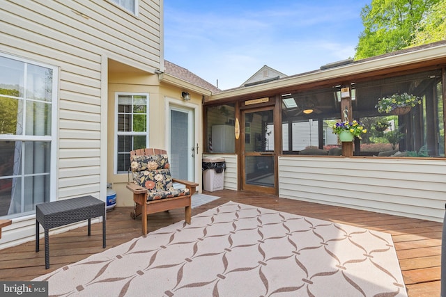 view of patio featuring a wooden deck and a sunroom