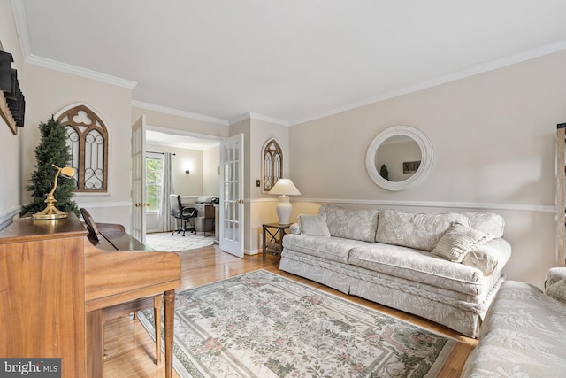 living room with french doors, crown molding, wood finished floors, and baseboards