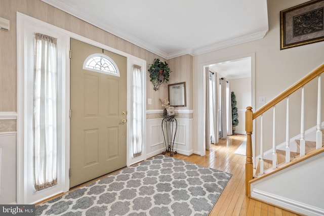 entrance foyer featuring stairway, crown molding, and wood-type flooring