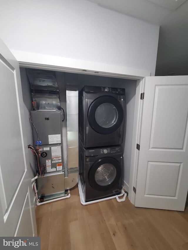 5100 Fitch St SE, Washington, DC 20019 - washroom featuring stacked washer and clothes dryer and wood finished floors