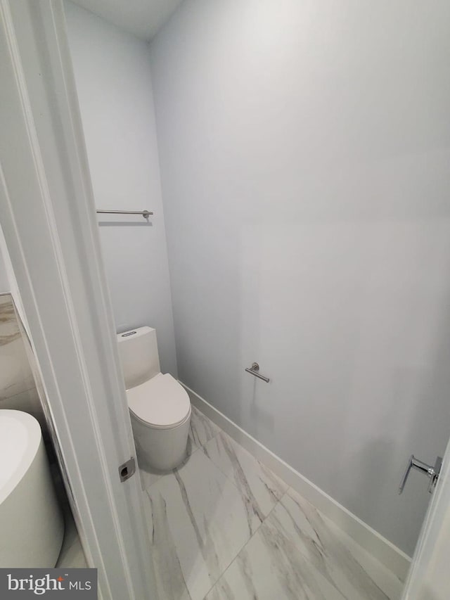 5100 Fitch St SE, Washington, DC 20019 - bathroom with marble look tiles, toilet, and baseboards