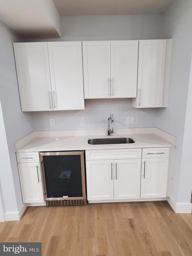 5100 Fitch St SE, Washington, DC 20019 - kitchen with a sink, white cabinets, light wood finished floors, and light countertops