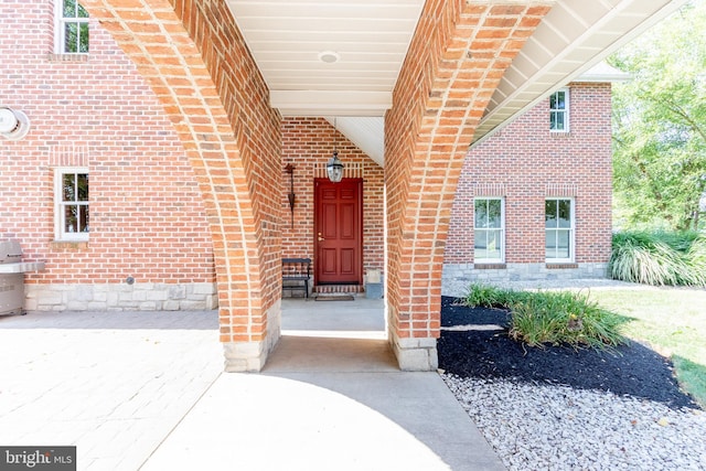 doorway to property featuring brick siding