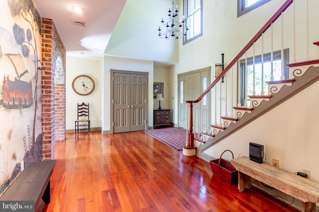 entryway featuring stairs, visible vents, wood finished floors, and plenty of natural light
