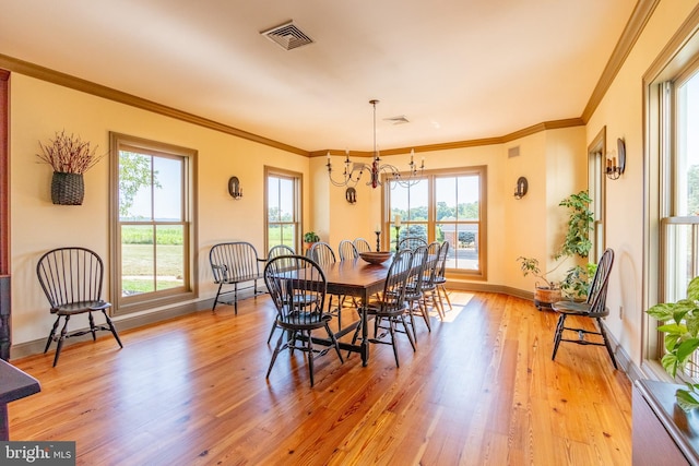 dining area with visible vents, a chandelier, baseboards, ornamental molding, and light wood finished floors