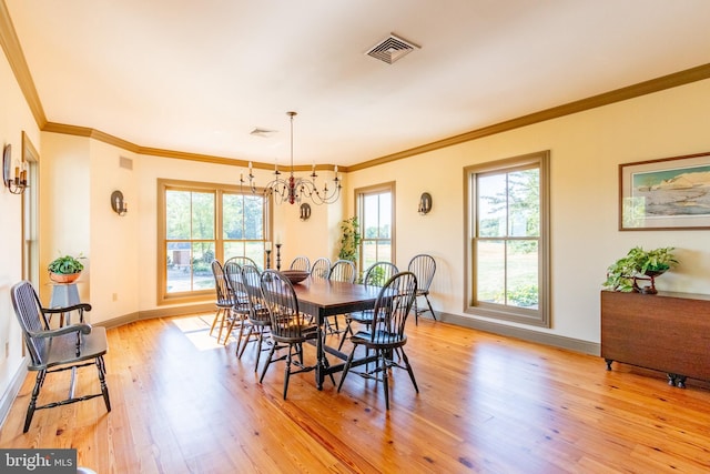 dining space featuring an inviting chandelier, ornamental molding, light wood finished floors, and baseboards