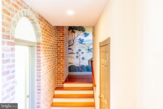 staircase with recessed lighting and brick wall