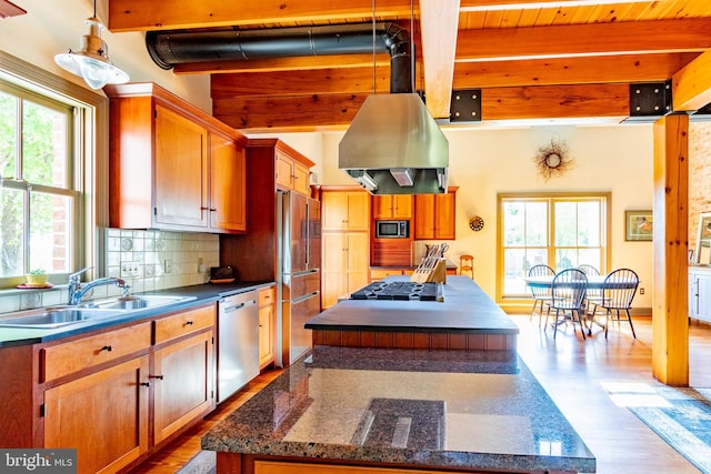 kitchen with a center island, beam ceiling, stainless steel appliances, and a healthy amount of sunlight