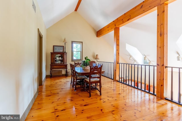dining area featuring lofted ceiling with skylight, visible vents, and hardwood / wood-style floors