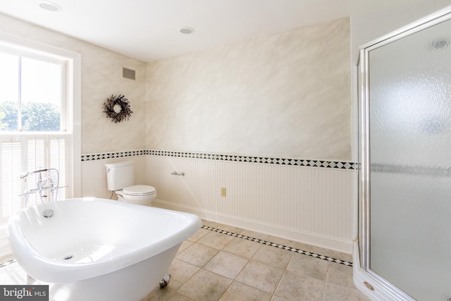 full bath featuring a freestanding tub, tile patterned floors, toilet, a stall shower, and visible vents