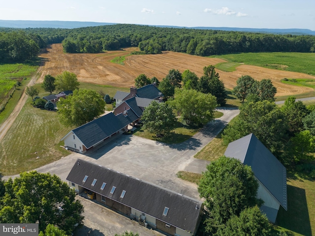 drone / aerial view with a wooded view and a rural view
