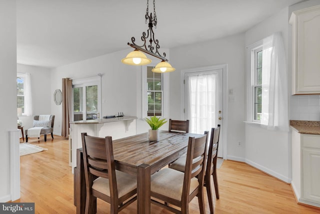 dining area with baseboards and light wood-style floors