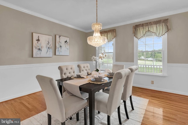 dining area featuring ornamental molding, an inviting chandelier, wood finished floors, and baseboards