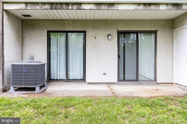 75 Ashlar Hill Ct Unit 75, Baltimore, MD 21234 - property entrance with cooling unit, stucco siding, and a patio