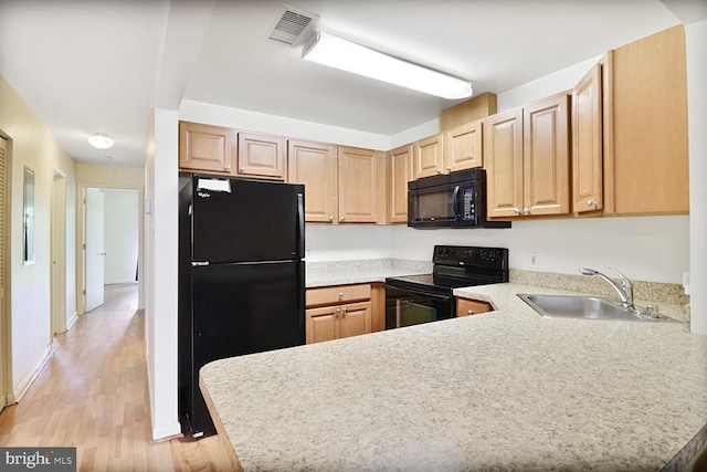 75 Ashlar Hill Ct Unit 75, Baltimore, MD 21234 - kitchen featuring black appliances, a sink, light countertops, a peninsula, and light wood-style flooring