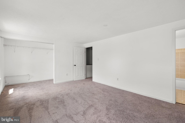 unfurnished bedroom featuring baseboards, carpet flooring, and a closet