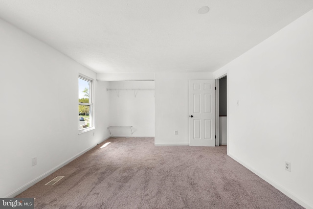 unfurnished bedroom featuring baseboards, visible vents, and carpet