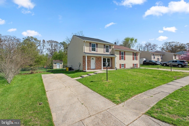 view of front of house with brick siding, driveway, a porch, and a front lawn