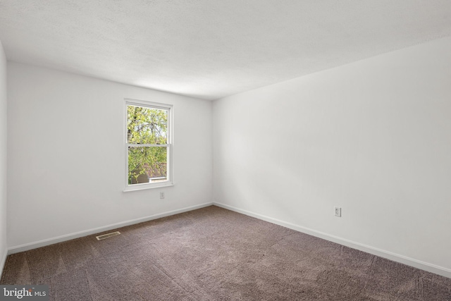 carpeted empty room with baseboards and visible vents