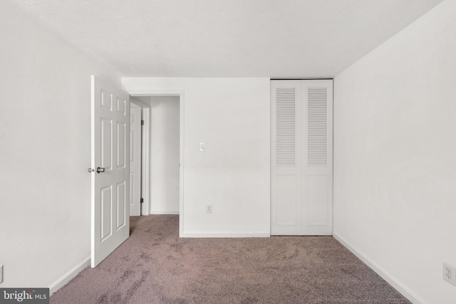 unfurnished bedroom featuring carpet, a closet, and baseboards