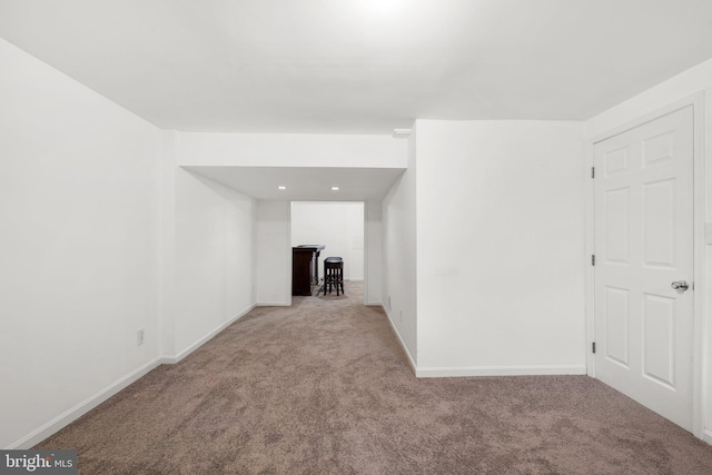 carpeted empty room featuring baseboards