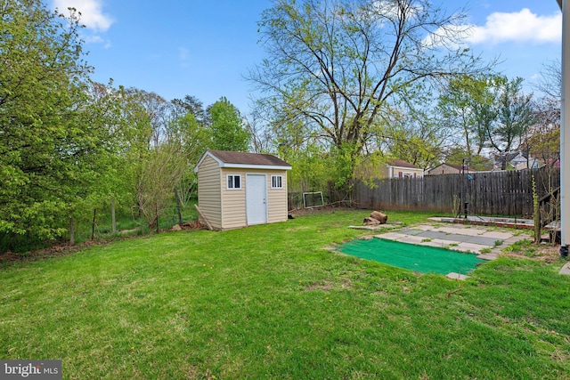 view of yard with a fenced backyard, an outbuilding, a patio area, and a storage unit