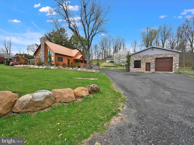 1918 Friedensburg Rd, Reading, PA 19606 - view of side of home featuring a chimney, aphalt driveway, an attached garage, stone siding, and a lawn