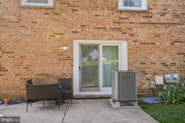 9060 Moonshine Holw Unit G, Laurel, MD 20723 - view of exterior entry featuring cooling unit, a patio area, and brick siding