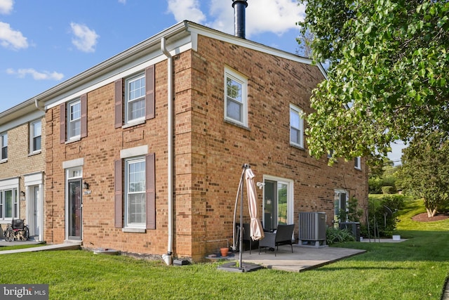 9060 Moonshine Holw Unit G, Laurel, MD 20723 - back of house with brick siding, a lawn, cooling unit, and a patio