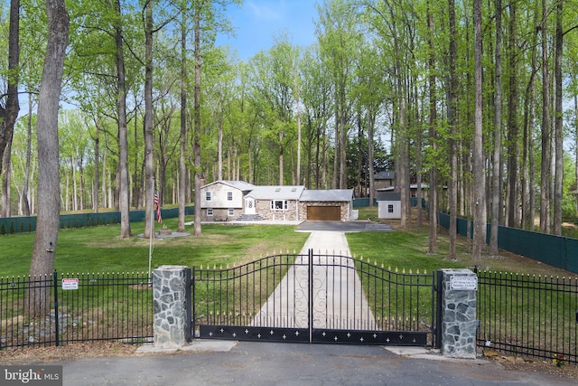 view of front of home with fence private yard, stone siding, a front lawn, and concrete driveway