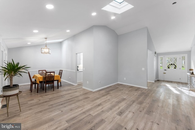 dining space with light wood finished floors, baseboards, recessed lighting, and vaulted ceiling with skylight
