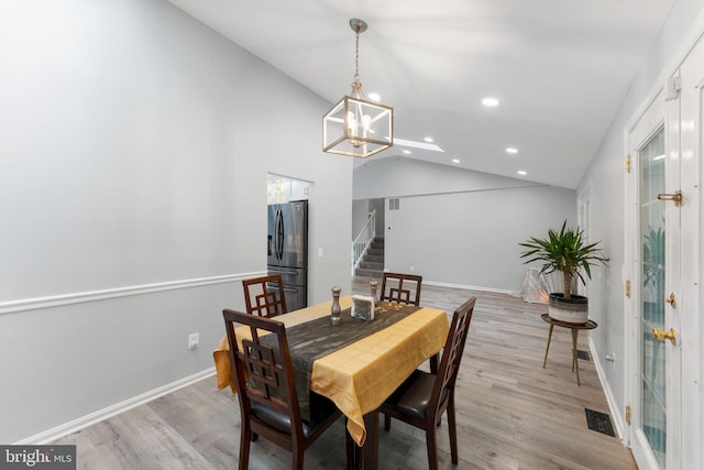 dining area with stairway, a chandelier, light wood-style flooring, lofted ceiling, and recessed lighting