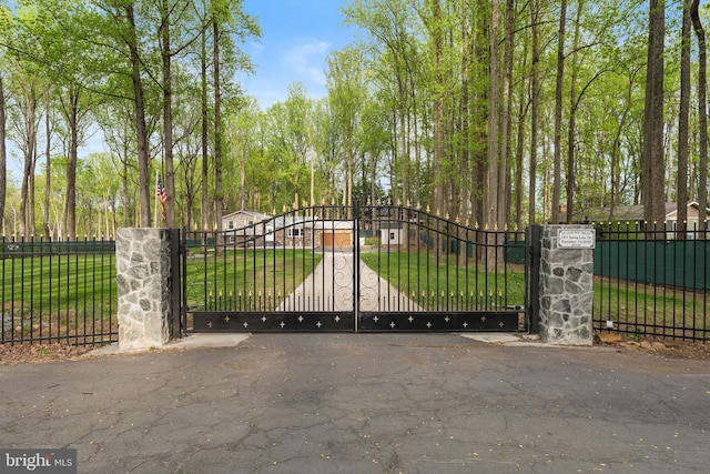 view of gate featuring fence and a yard