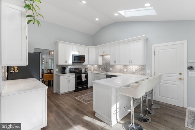 kitchen featuring backsplash, white cabinetry, stainless steel appliances, and a sink