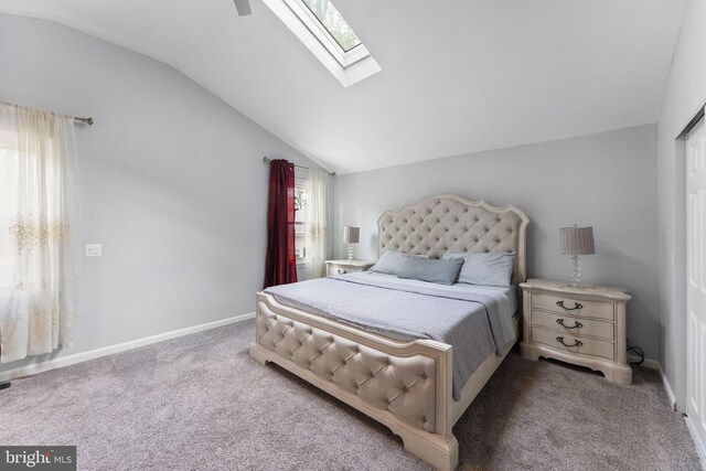 carpeted bedroom featuring baseboards and lofted ceiling with skylight