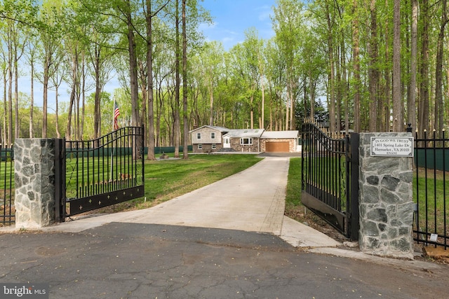 view of gate with a lawn and fence