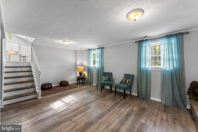 sitting room featuring a wealth of natural light, wood finished floors, and a textured ceiling