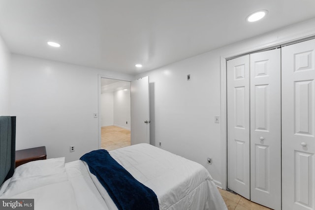 bedroom with light tile patterned flooring, a closet, and recessed lighting
