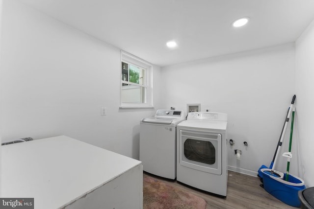 washroom featuring recessed lighting, laundry area, wood finished floors, washing machine and dryer, and baseboards
