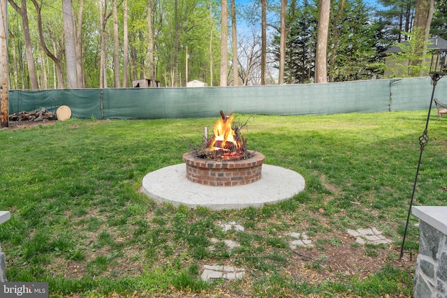 view of yard with fence and a fire pit