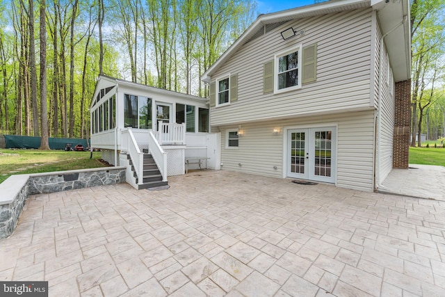 rear view of house with a patio area, french doors, a sunroom, and stairs