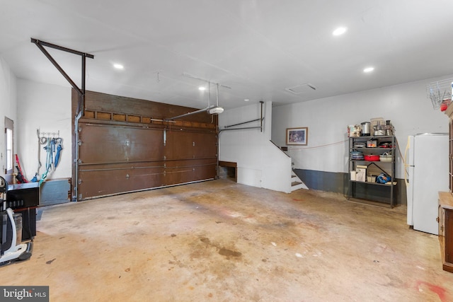 garage featuring recessed lighting and freestanding refrigerator