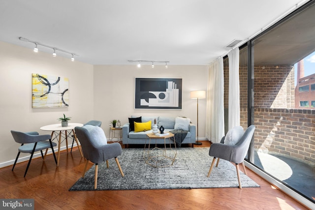 living room featuring baseboards, wood finished floors, and rail lighting