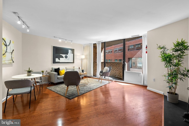 living room featuring track lighting, wood finished floors, and baseboards