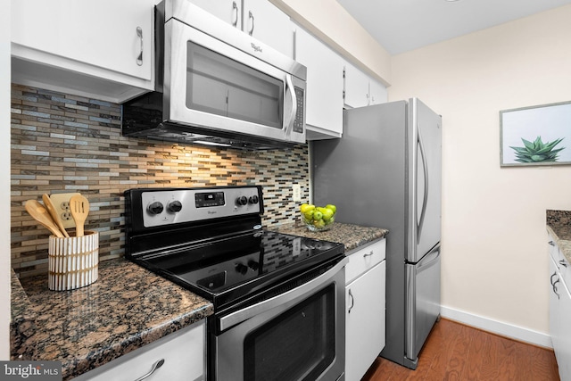 kitchen featuring white cabinets, stainless steel appliances, light wood-type flooring, baseboards, and tasteful backsplash