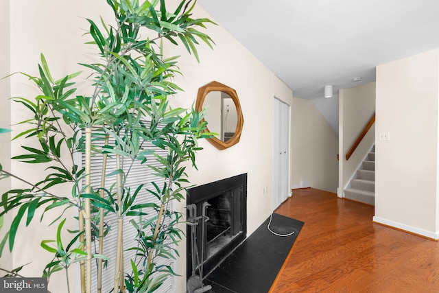 interior space featuring wood finished floors, a fireplace, and stairway