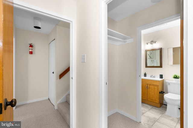 bathroom featuring toilet, vanity, and baseboards